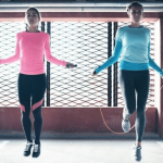 two woman jumping ropes as they work out