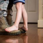 a child standing a soldier's boots
