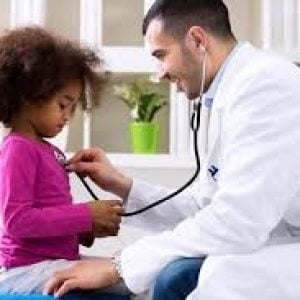 a doctor checking a young girl's heart rate with his stethoscope